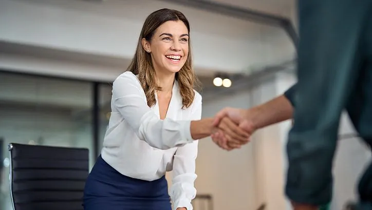 Glad middelaldrende forretningskvinne leder handshaking hilsen klient på kontoret